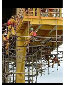 Crew erecting scaffold beneath a platform deck