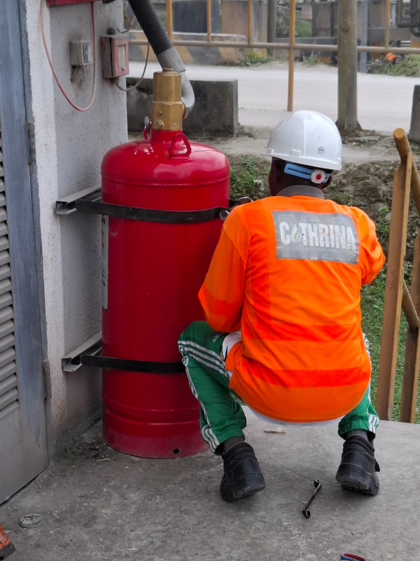 Engineer mounting a wall-bracketed fire suppression cylinder