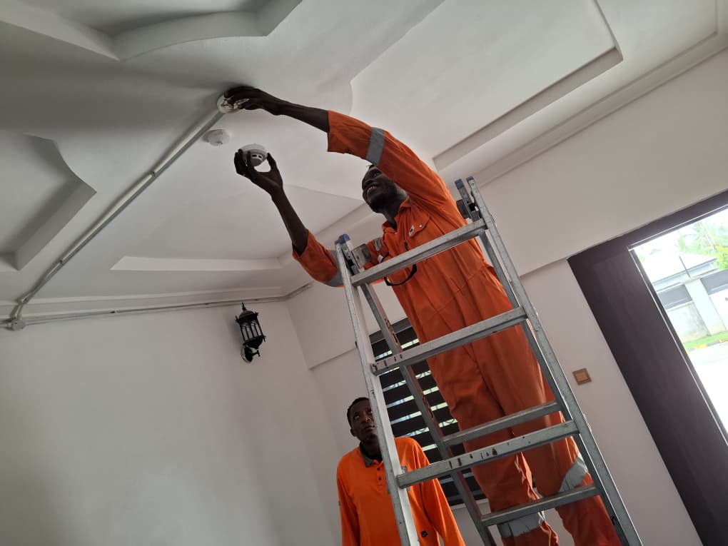 Two technicians commissioning ceiling-mounted smoke detectors